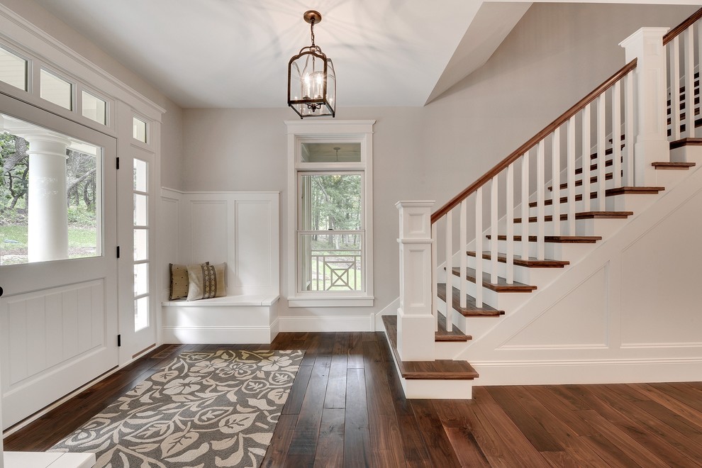 This is an example of a mid-sized transitional foyer in Minneapolis with a white front door, grey walls, dark hardwood floors, a single front door and brown floor.