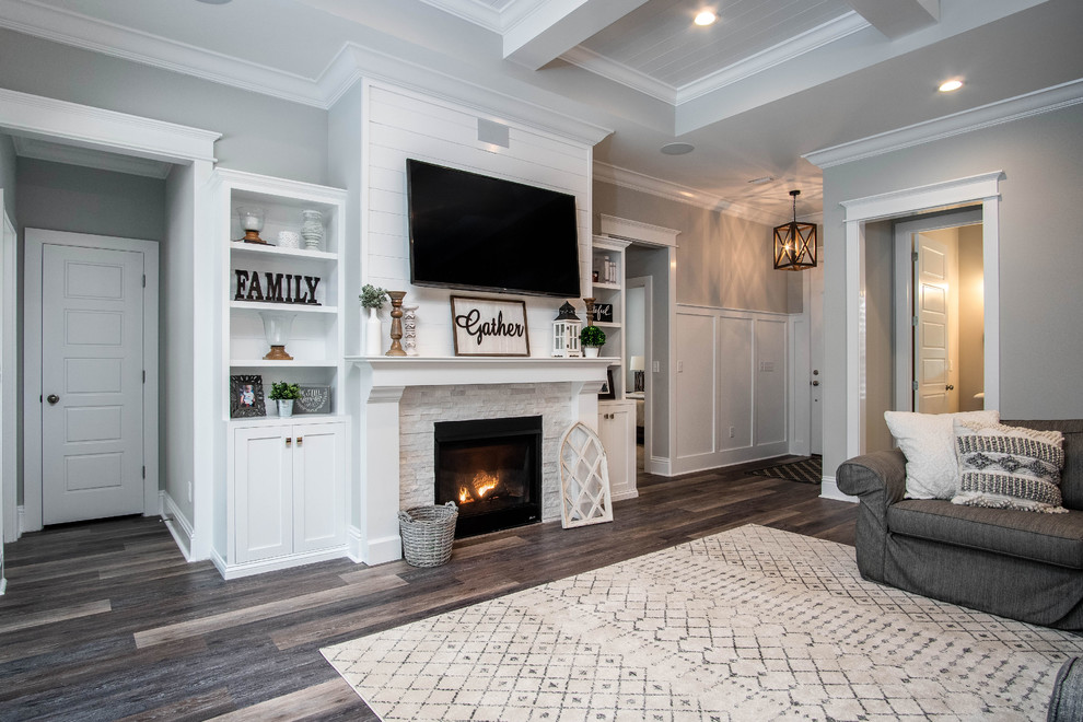 Design ideas for a large country open concept family room in Jacksonville with grey walls, vinyl floors, a standard fireplace, a stone fireplace surround, a wall-mounted tv and brown floor.