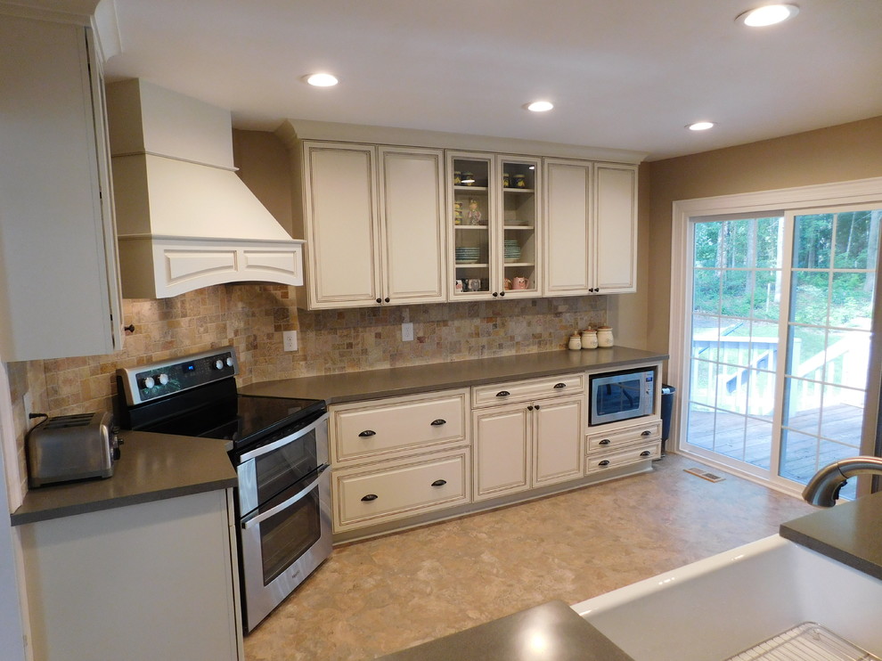 Inspiration for a mid-sized transitional galley vinyl floor enclosed kitchen remodel with a farmhouse sink, raised-panel cabinets, beige cabinets, solid surface countertops, multicolored backsplash, stone tile backsplash, stainless steel appliances and no island