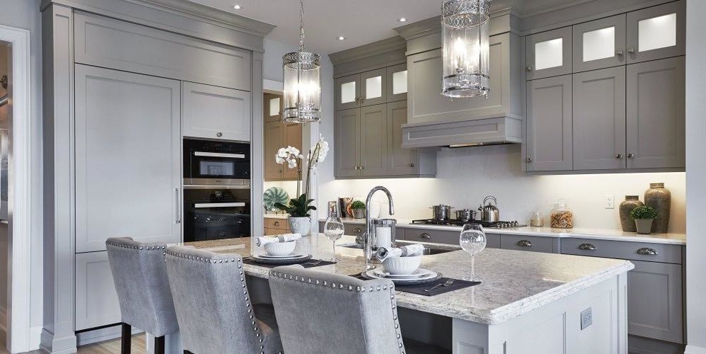 Large transitional u-shaped porcelain tile and gray floor kitchen photo in Miami with an undermount sink, recessed-panel cabinets, gray cabinets, granite countertops, paneled appliances and an island