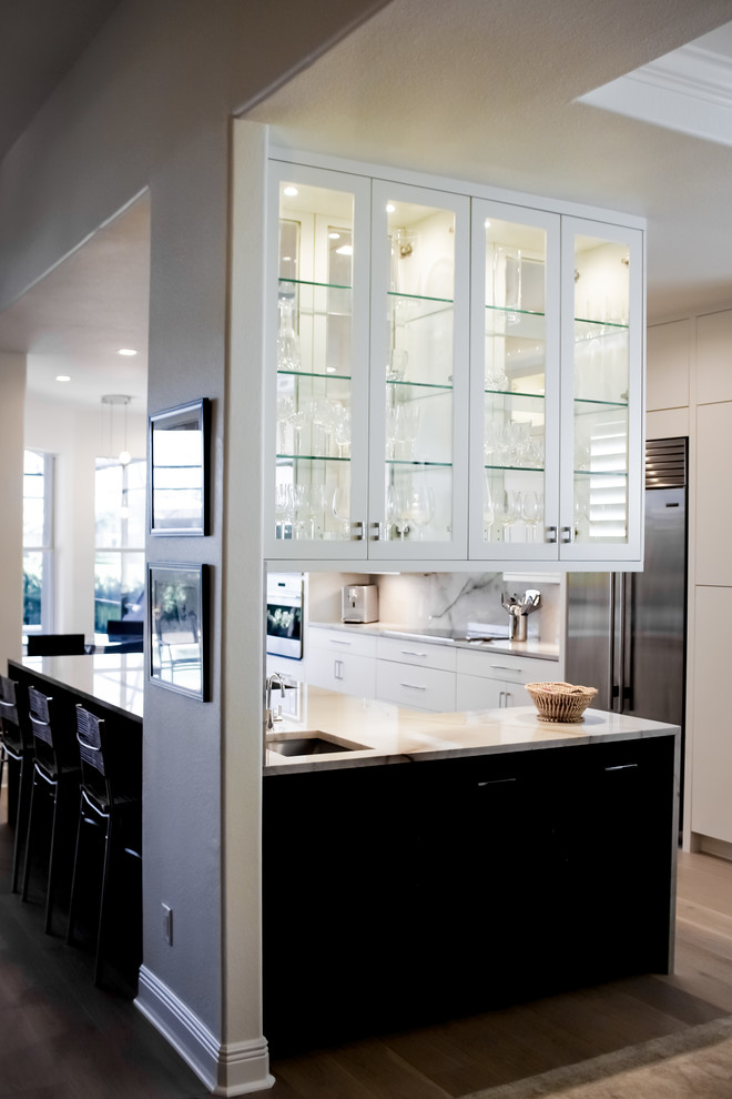 Inspiration for a mid-sized modern l-shaped eat-in kitchen in Miami with a double-bowl sink, flat-panel cabinets, white cabinets, marble benchtops, grey splashback, marble splashback, stainless steel appliances, light hardwood floors, with island, grey floor and grey benchtop.