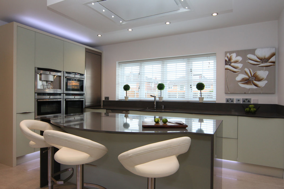 This is an example of a contemporary kitchen with flat-panel cabinets, grey cabinets and stainless steel appliances.
