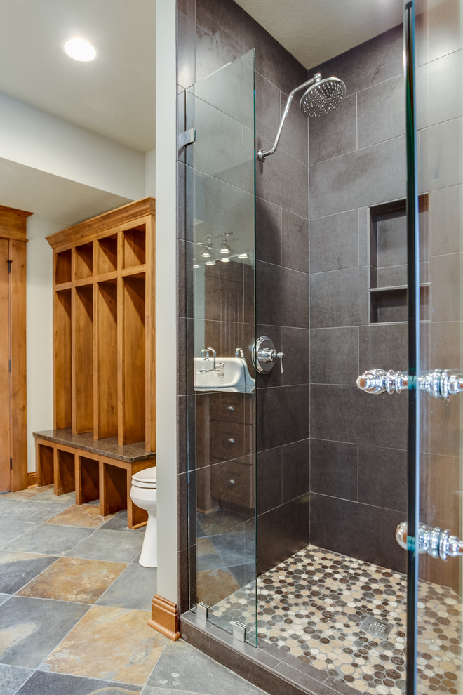 Example of a large mountain style multicolored tile and stone tile slate floor doorless shower design with a console sink, flat-panel cabinets, medium tone wood cabinets, granite countertops, a two-piece toilet and beige walls