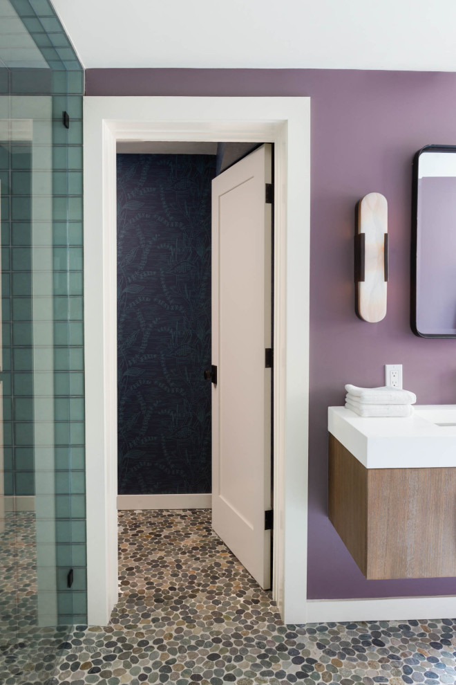 Modelo de cuarto de baño principal, doble y a medida contemporáneo de tamaño medio con armarios con paneles lisos, puertas de armario violetas, bañera esquinera, sanitario de una pieza, paredes púrpuras, suelo con mosaicos de baldosas, lavabo bajoencimera, encimera de cuarzo compacto y encimeras blancas