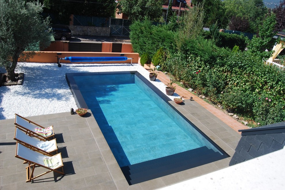Photo of a mid-sized country front yard rectangular lap pool in Madrid with a pool house.