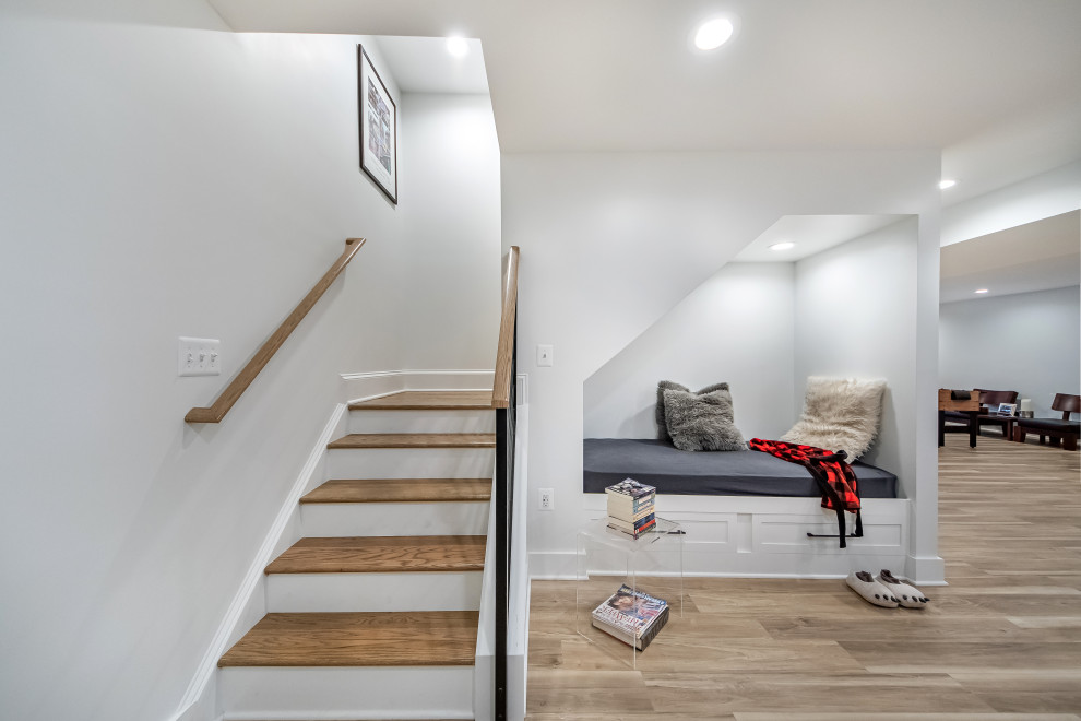 Photo of a small transitional walk-out basement in DC Metro with white walls, vinyl floors, no fireplace and brown floor.