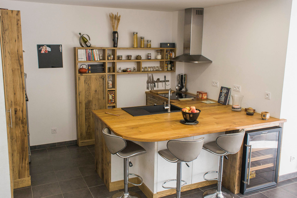 Inspiration pour cuisine américaine in L With un évier 1 bac, des portes de placard marrons, un plan de travail en bois, un sol en carrelage de céramique and une péninsule.