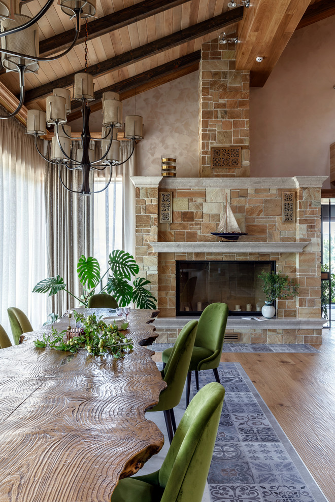 Inspiration for a country open plan dining in Other with beige walls, a standard fireplace and a tile fireplace surround.