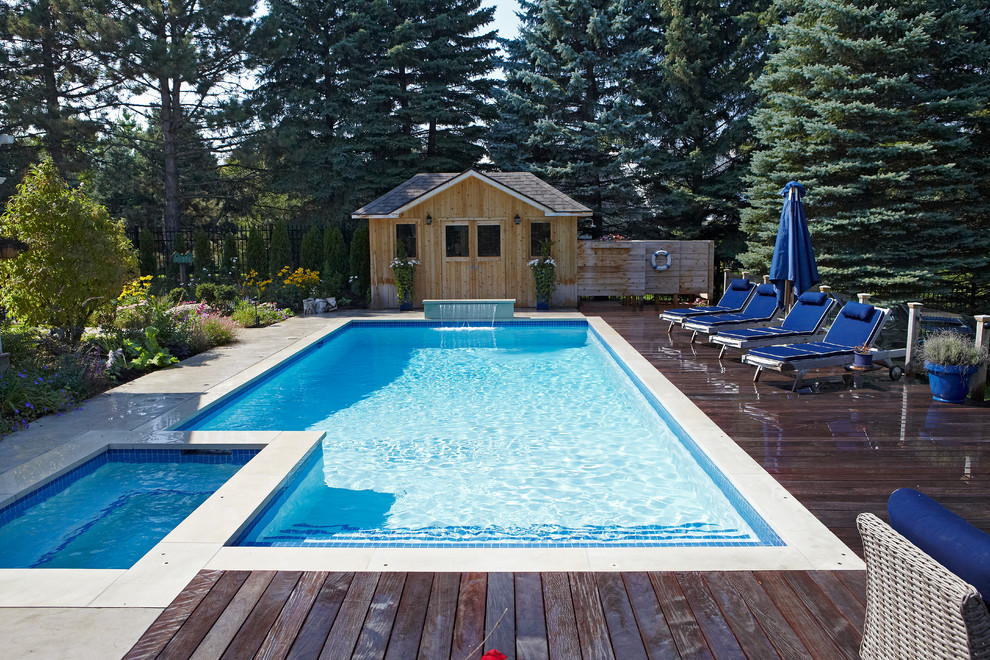 Mid-sized modern backyard rectangular lap pool in Toronto with a hot tub and concrete pavers.
