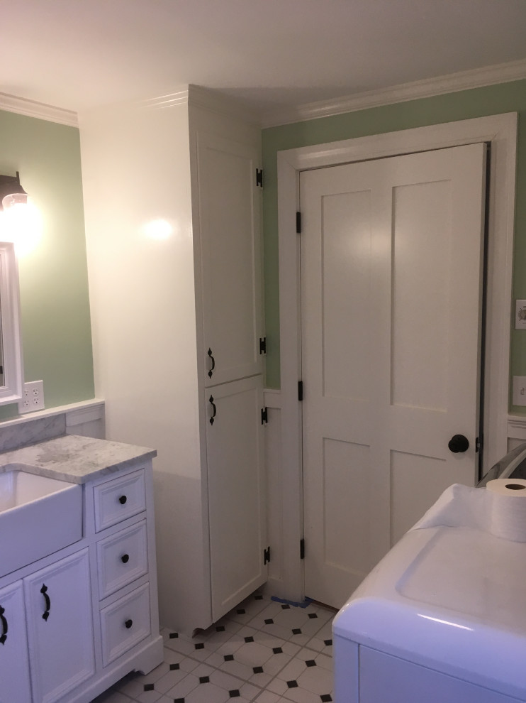 Photo of a large country bathroom in Other with beaded inset cabinets, white cabinets, an alcove tub, a shower/bathtub combo, a two-piece toilet, green walls, an undermount sink, marble benchtops, multi-coloured floor, multi-coloured benchtops, a laundry, a single vanity, a freestanding vanity and decorative wall panelling.