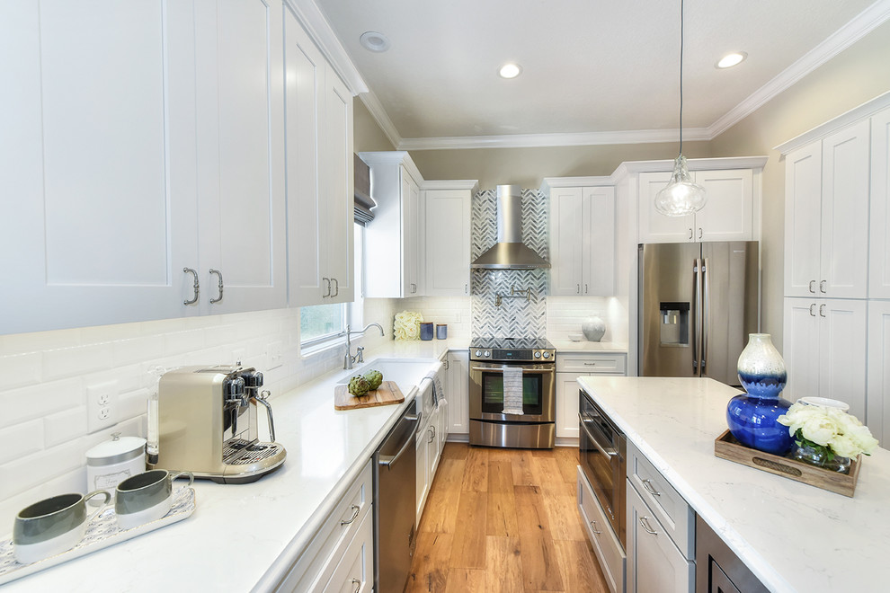 Large transitional l-shaped medium tone wood floor eat-in kitchen photo in Jacksonville with a farmhouse sink, shaker cabinets, quartz countertops and an island