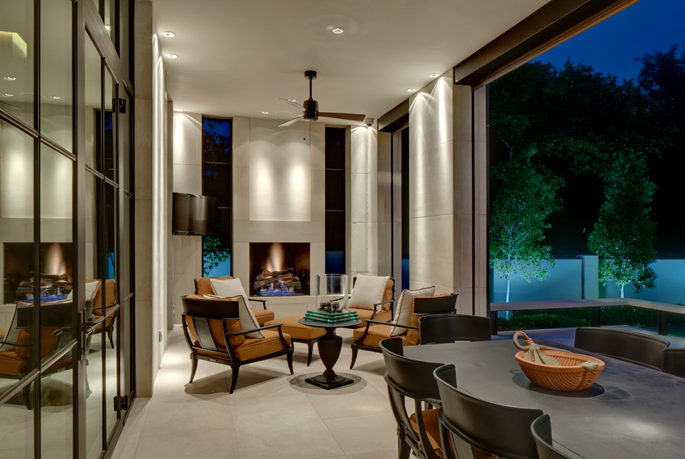 This is an example of a contemporary patio in Dallas with a fire feature and a roof extension.