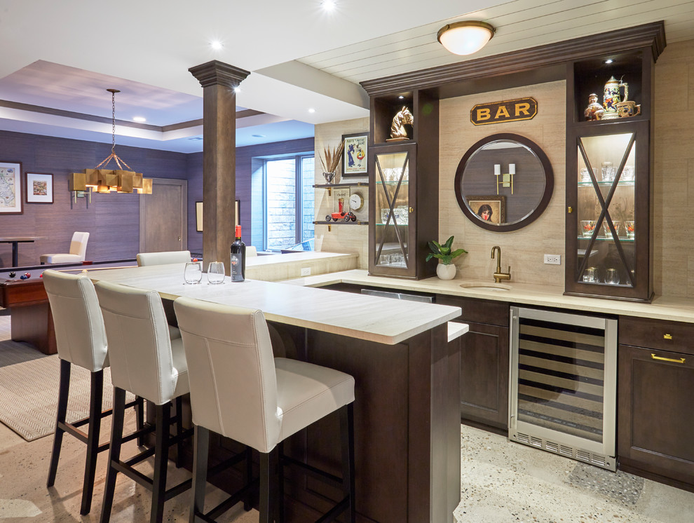 Inspiration for a transitional u-shaped home bar in Chicago with an undermount sink, glass-front cabinets, dark wood cabinets, beige splashback, multi-coloured floor and beige benchtop.