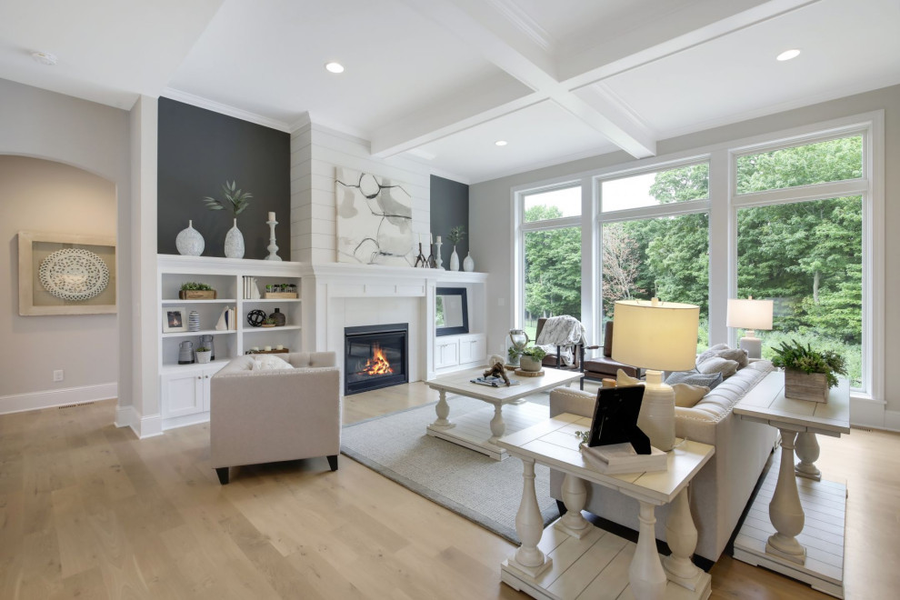 Photo of a transitional formal open concept living room in Minneapolis with grey walls, medium hardwood floors, a standard fireplace, no tv, beige floor and coffered.