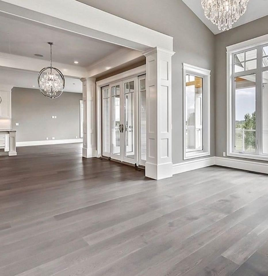 Design ideas for an expansive traditional formal open concept living room in Surrey with white walls, painted wood floors, a two-sided fireplace, a stone fireplace surround, a built-in media wall, brown floor, timber and wallpaper.