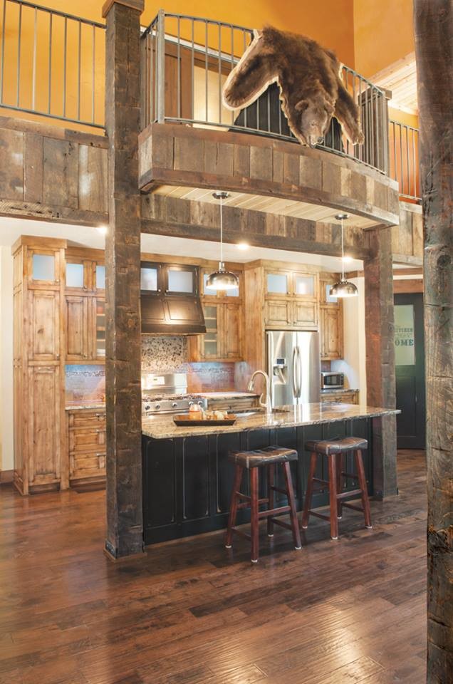 Kitchen - rustic kitchen idea with an undermount sink, raised-panel cabinets, distressed cabinets, granite countertops, gray backsplash, stainless steel appliances, engineered wood floors and an island