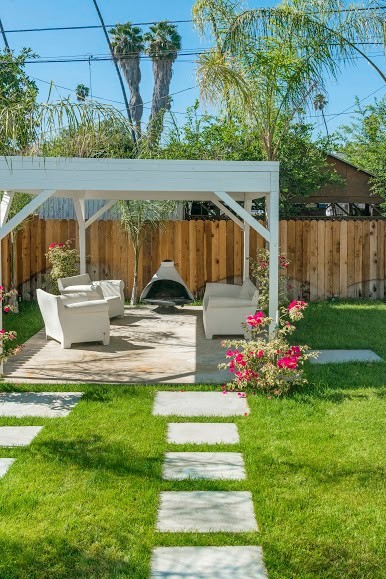 Design ideas for a mid-sized tropical backyard shaded garden for spring in Los Angeles with a garden path and decking.