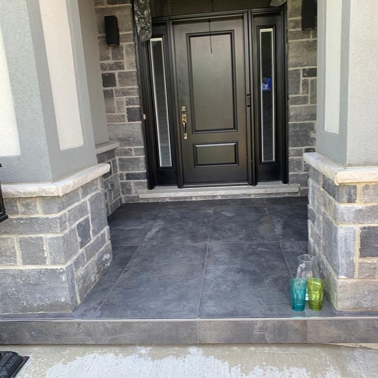 This is an example of a mid-sized traditional front yard verandah in Toronto with tile and a roof extension.
