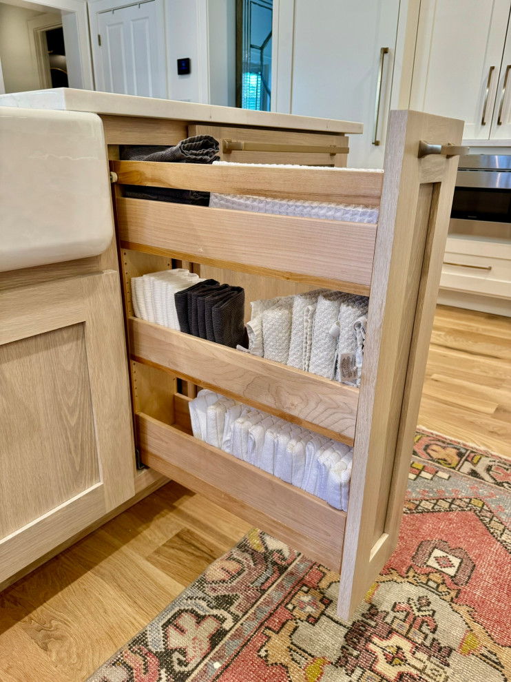 Mid-sized transitional l-shaped light wood floor, brown floor and wallpaper ceiling eat-in kitchen photo in Atlanta with a farmhouse sink, shaker cabinets, white cabinets, granite countertops, white backsplash, stainless steel appliances, an island and white countertops
