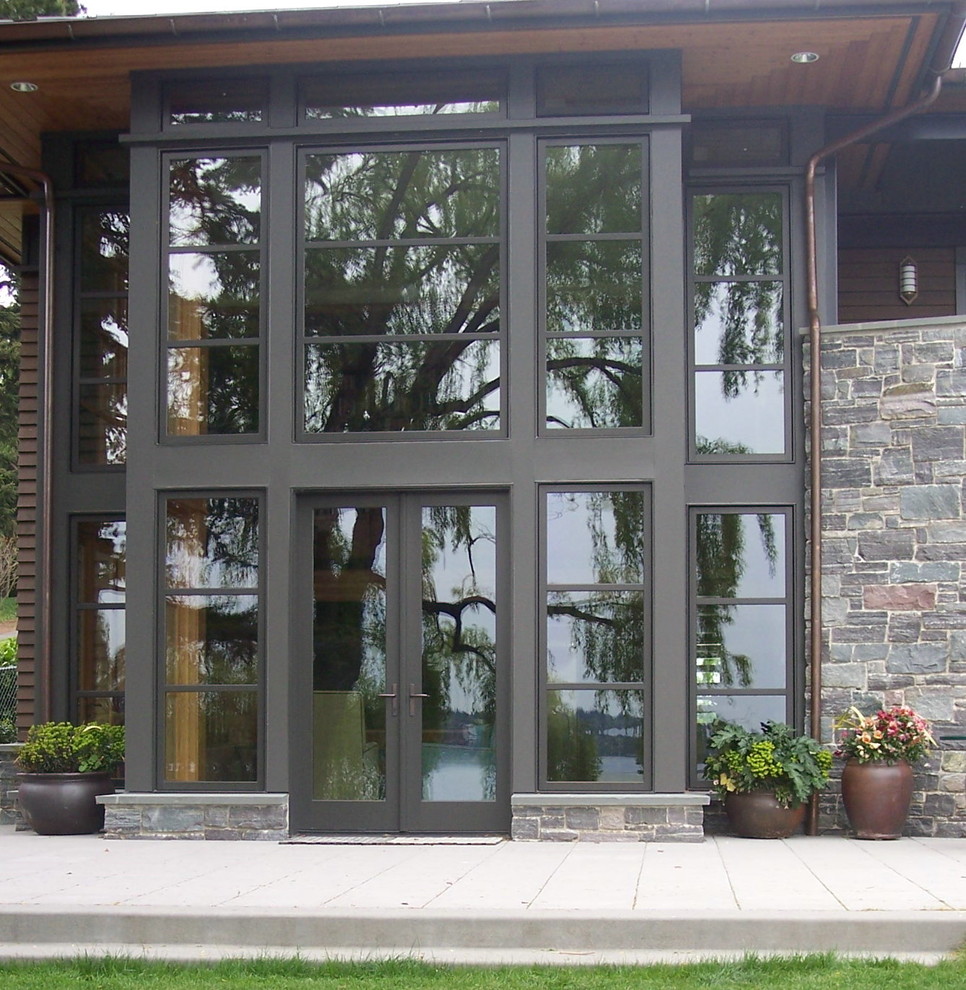 Photo of a transitional two-storey exterior in Seattle with stone veneer.