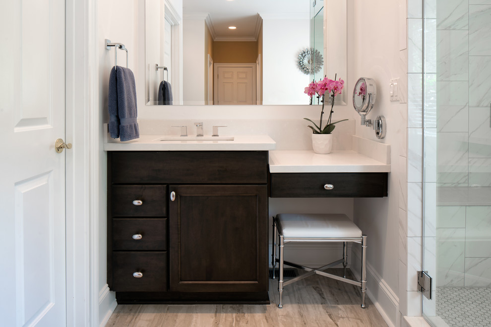 Mid-sized contemporary master bathroom in Charlotte with recessed-panel cabinets, dark wood cabinets, a freestanding tub, a corner shower, a two-piece toilet, white tile, porcelain tile, white walls, porcelain floors, an undermount sink, engineered quartz benchtops, a hinged shower door and beige floor.