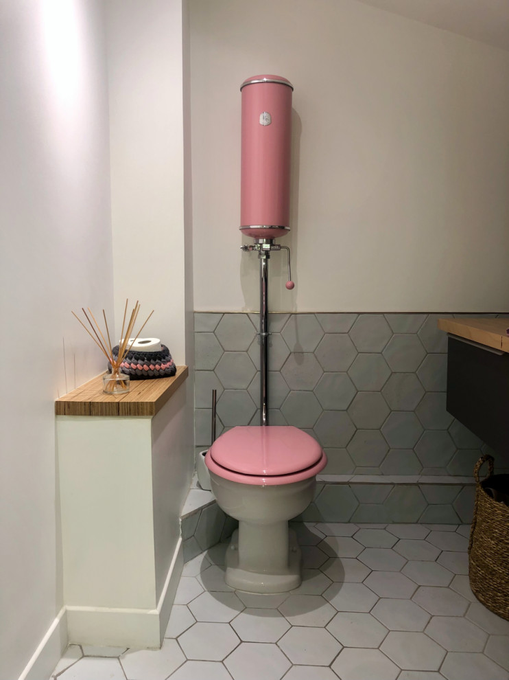 Exempel på ett litet modernt toalett, med grå skåp, en toalettstol med hel cisternkåpa, vit kakel, keramikplattor och träbänkskiva
