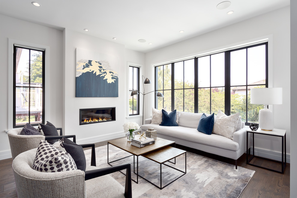 This is an example of a mid-sized transitional open concept living room in Vancouver with a plaster fireplace surround, brown floor, white walls, dark hardwood floors and a ribbon fireplace.