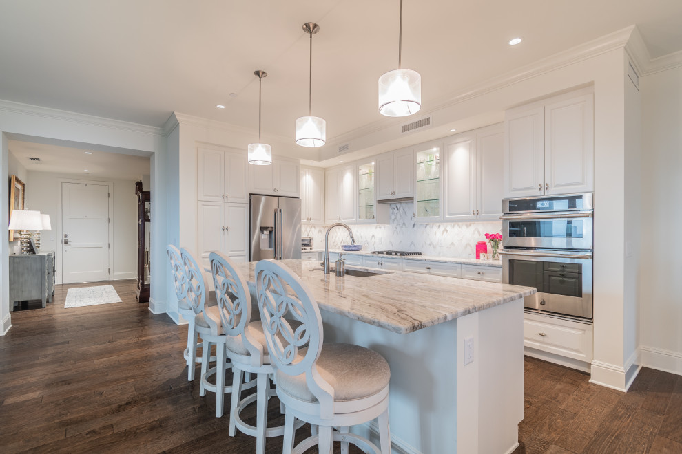 Design ideas for a mid-sized transitional l-shaped separate kitchen in Tampa with an undermount sink, shaker cabinets, white cabinets, granite benchtops, stainless steel appliances, medium hardwood floors, with island and white benchtop.