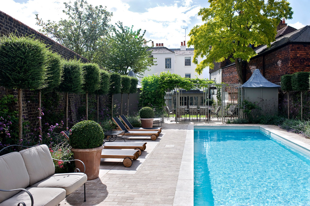 Contemporary rectangular lap pool in London with brick pavers.