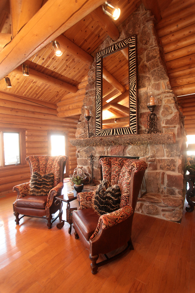 This is an example of a country open concept family room in Austin with medium hardwood floors, a two-sided fireplace, a stone fireplace surround and a corner tv.