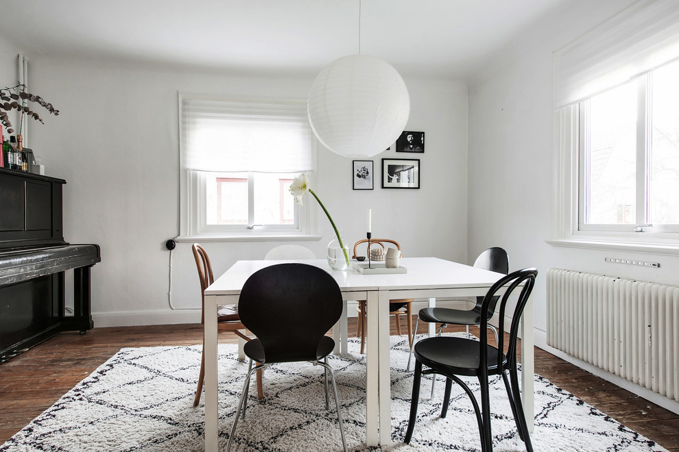 Mid-sized scandinavian dining room in Gothenburg with white walls, dark hardwood floors and brown floor.