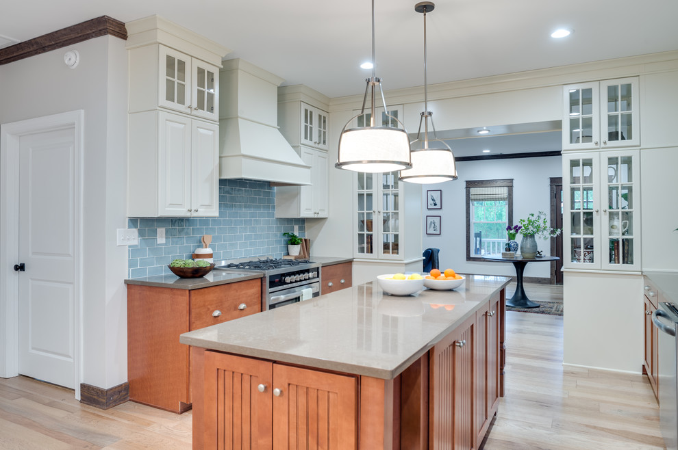 Enclosed kitchen - large transitional u-shaped light wood floor and beige floor enclosed kitchen idea in Indianapolis with recessed-panel cabinets, medium tone wood cabinets, quartz countertops, blue backsplash, subway tile backsplash, stainless steel appliances, an island and gray countertops