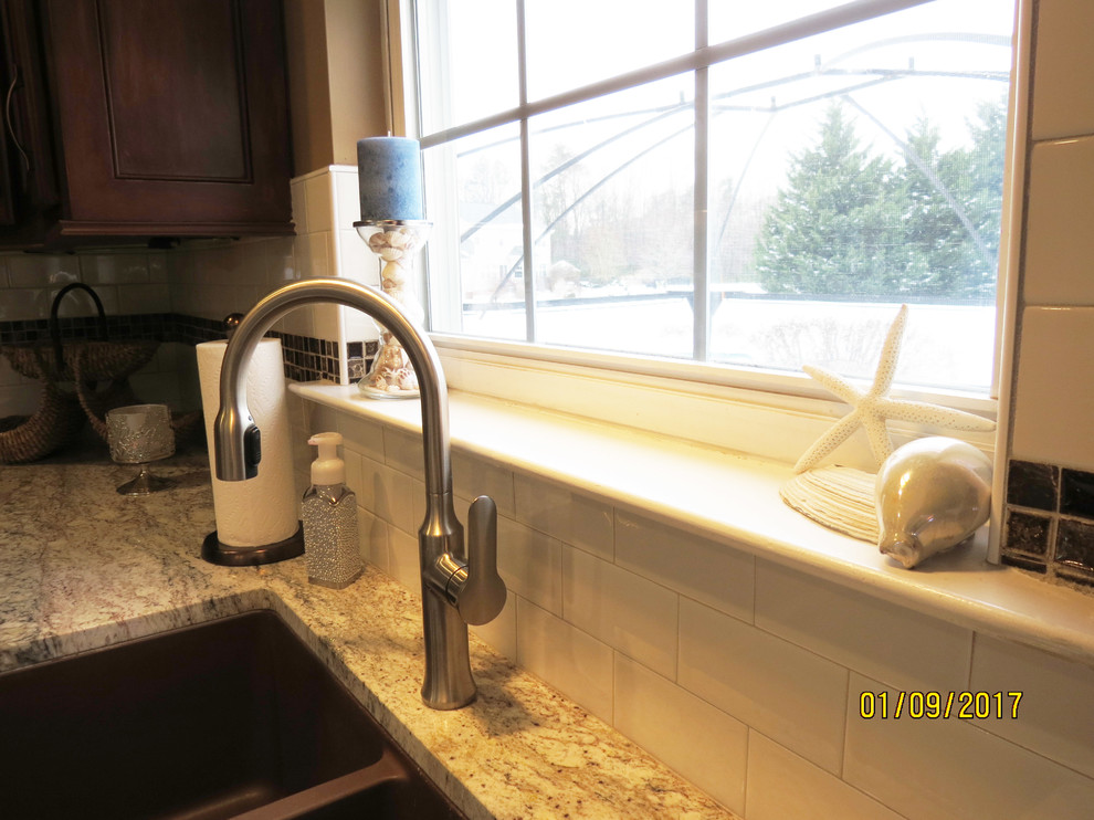 Mid-sized transitional l-shaped ceramic tile eat-in kitchen photo with an undermount sink, raised-panel cabinets, distressed cabinets, granite countertops, white backsplash, porcelain backsplash, stainless steel appliances and an island