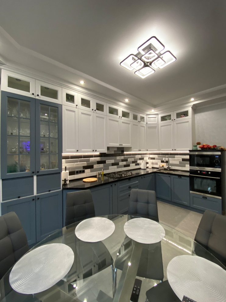 Photo of a medium sized classic l-shaped kitchen/diner in Moscow with white cabinets, engineered stone countertops, no island and black worktops.