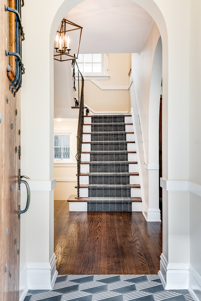 Photo of a transitional wood straight staircase in Chicago with carpet risers and metal railing.