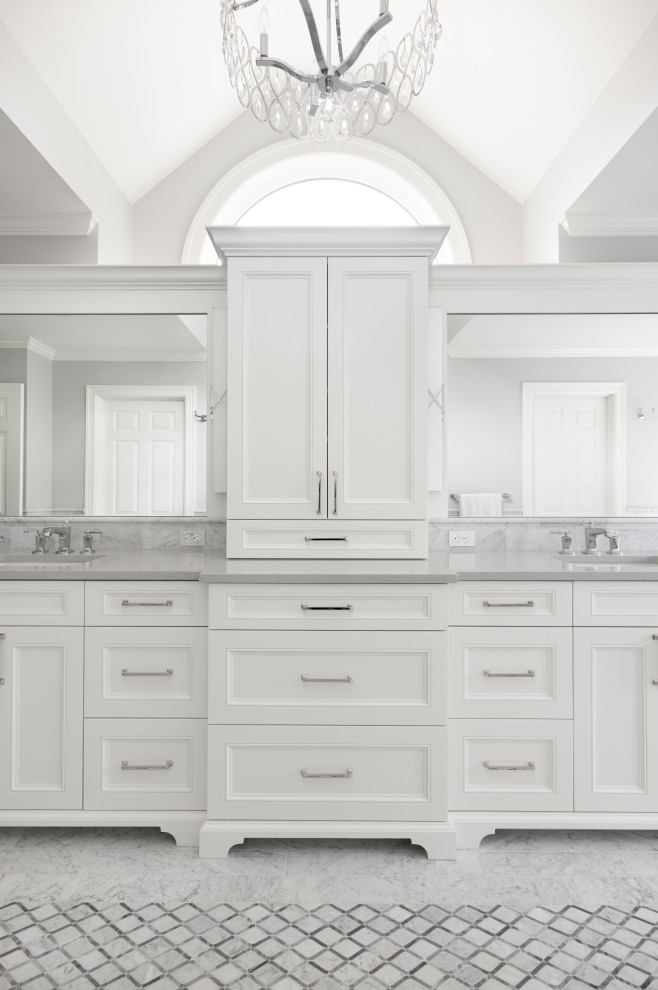 Inspiration for a large classic ensuite bathroom in Portland with beaded cabinets, white cabinets, a freestanding bath, a double shower, white tiles, marble tiles, marble flooring, a submerged sink, engineered stone worktops, white floors, a hinged door, grey worktops, a wall niche, double sinks, a built in vanity unit and a vaulted ceiling.