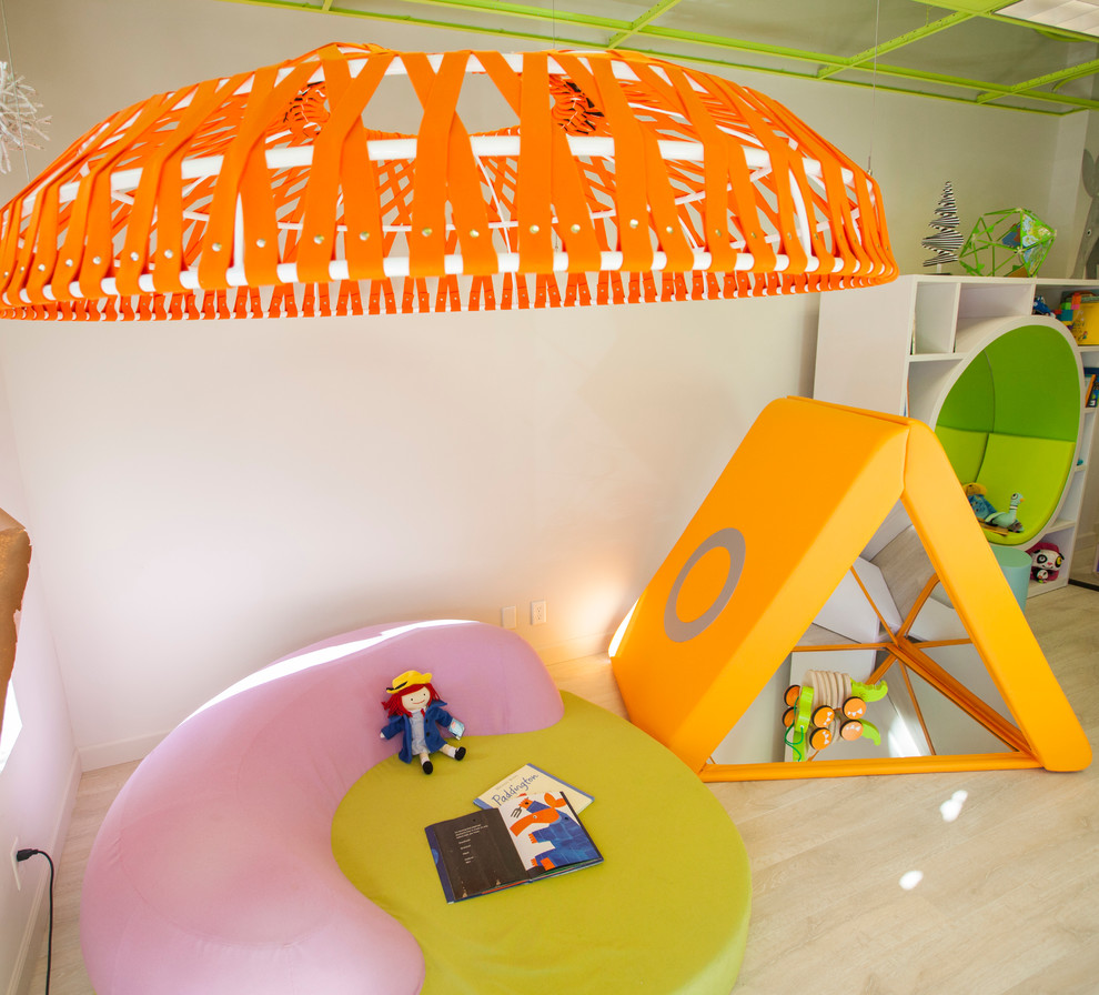 Inspiration for a large modern gender-neutral kids' playroom for kids 4-10 years old in Omaha with white walls and light hardwood floors.