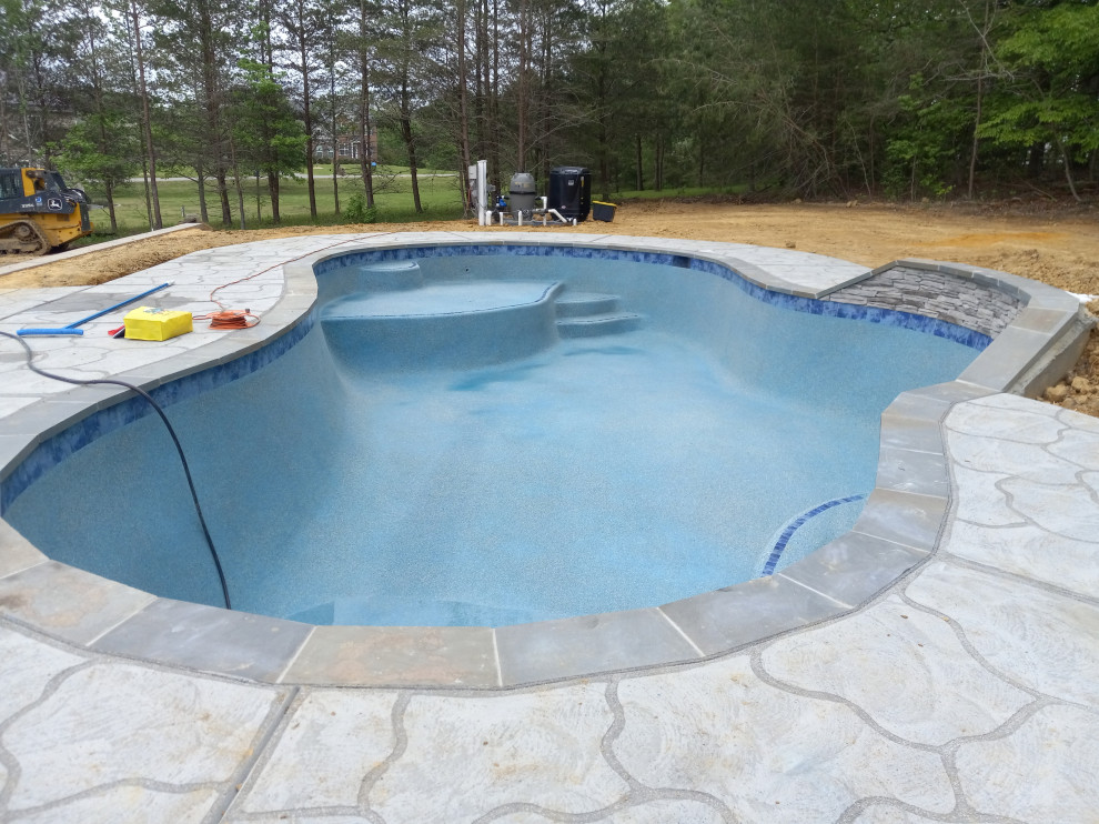 This is an example of a medium sized traditional back custom shaped swimming pool in DC Metro with concrete slabs.