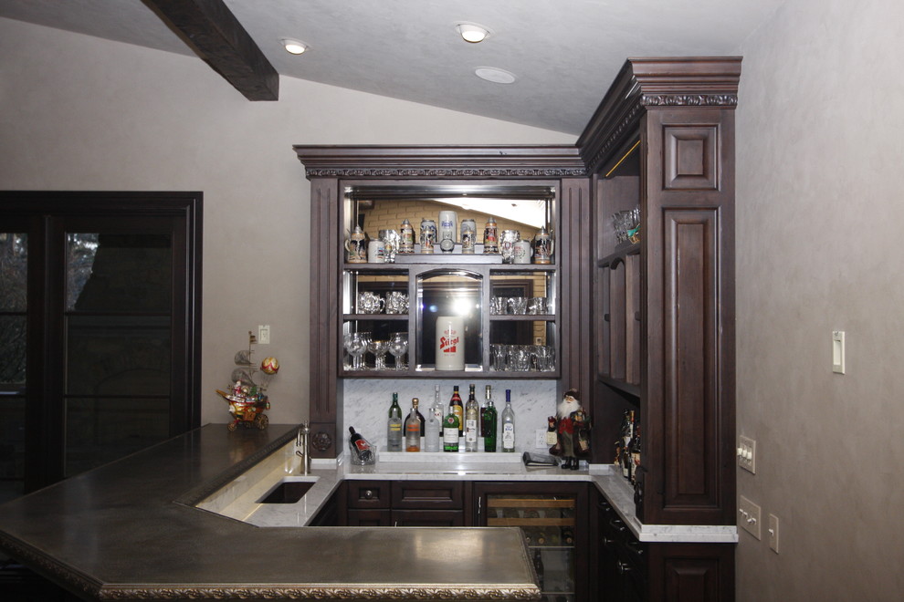 Small traditional l-shaped seated home bar in Wichita with an undermount sink, recessed-panel cabinets, dark wood cabinets, zinc benchtops, white splashback and marble splashback.