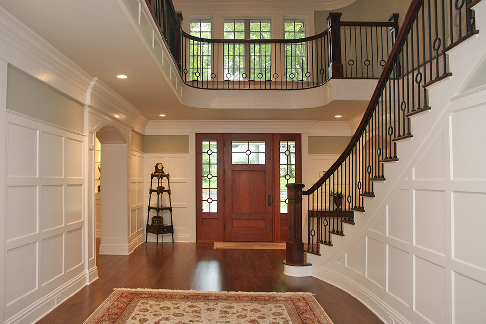 Photo of a mid-sized traditional foyer in Other with white walls, medium hardwood floors, a single front door, a medium wood front door and brown floor.