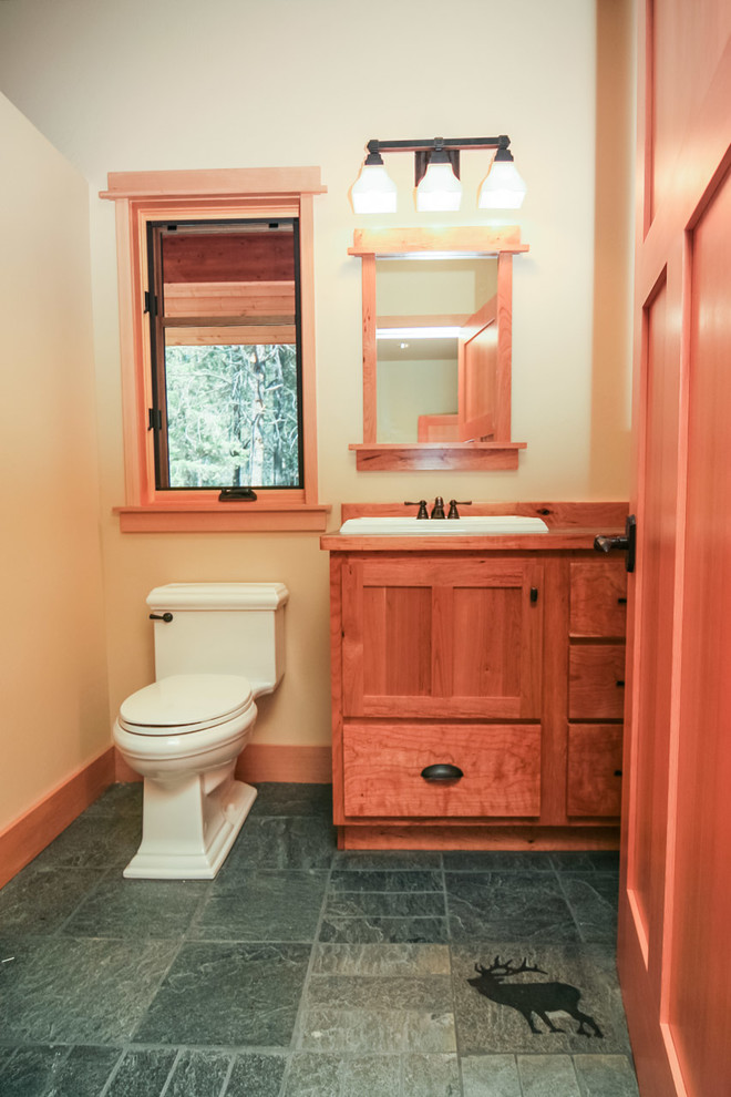 Photo of a mid-sized arts and crafts master bathroom in Other with a drop-in sink, shaker cabinets, light wood cabinets, laminate benchtops, a one-piece toilet, gray tile, beige walls and slate floors.