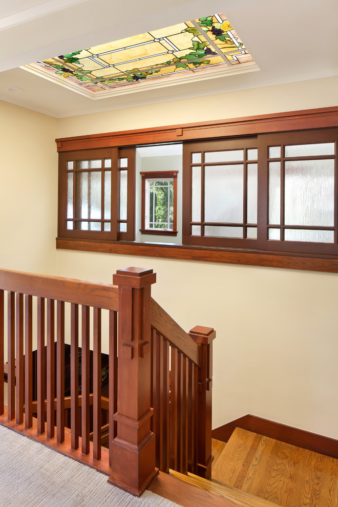 This is an example of a mid-sized arts and crafts wood u-shaped staircase in San Francisco with wood railing.