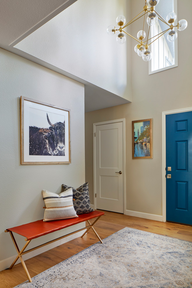 Mid-sized scandinavian foyer in Denver with beige walls, light hardwood floors, a single front door, a blue front door and brown floor.