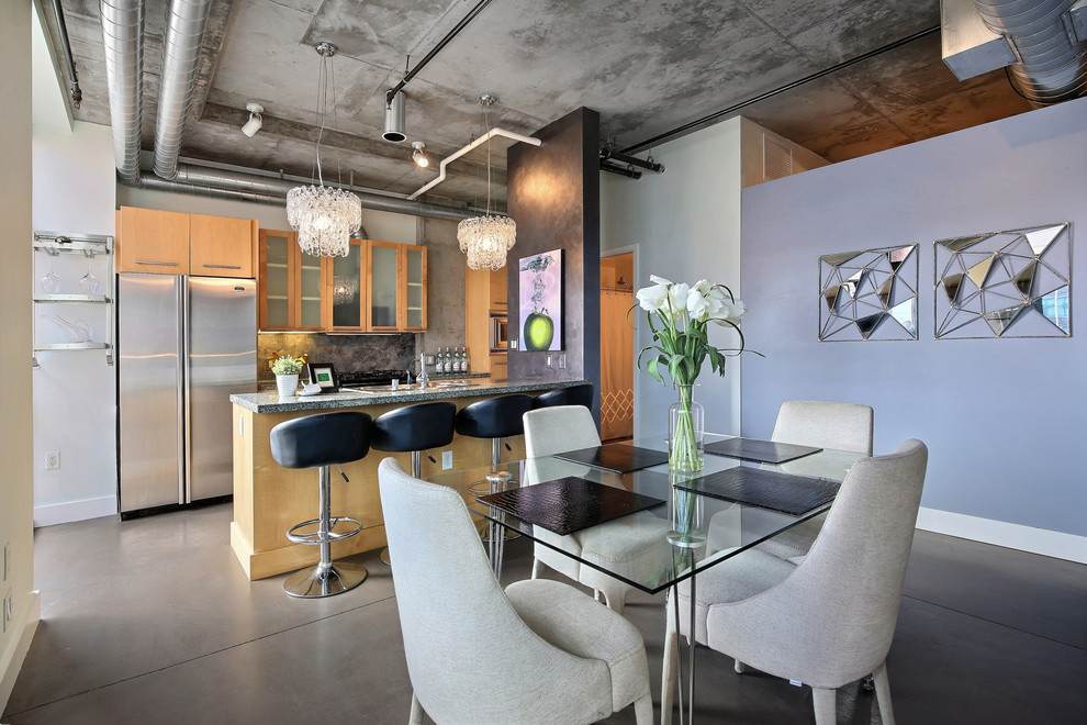 Photo of an industrial kitchen/dining combo in Denver with concrete floors, no fireplace and purple walls.