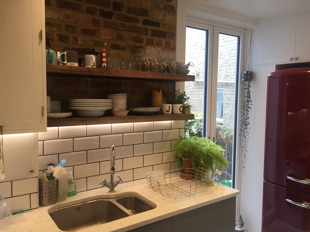 Small modern galley separate kitchen in London with a double-bowl sink, shaker cabinets, grey cabinets, quartzite benchtops, white splashback, subway tile splashback, painted wood floors, no island, white floor and yellow benchtop.