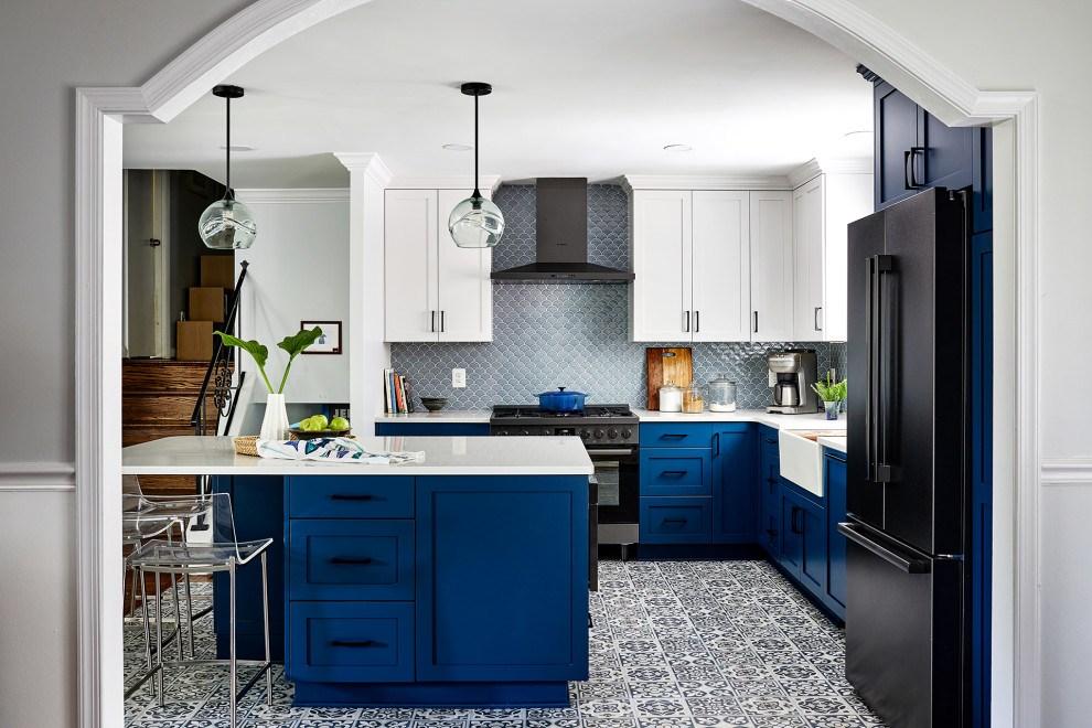 Transitional l-shaped blue floor eat-in kitchen photo in DC Metro with a farmhouse sink, blue cabinets, blue backsplash, black appliances, an island and white countertops