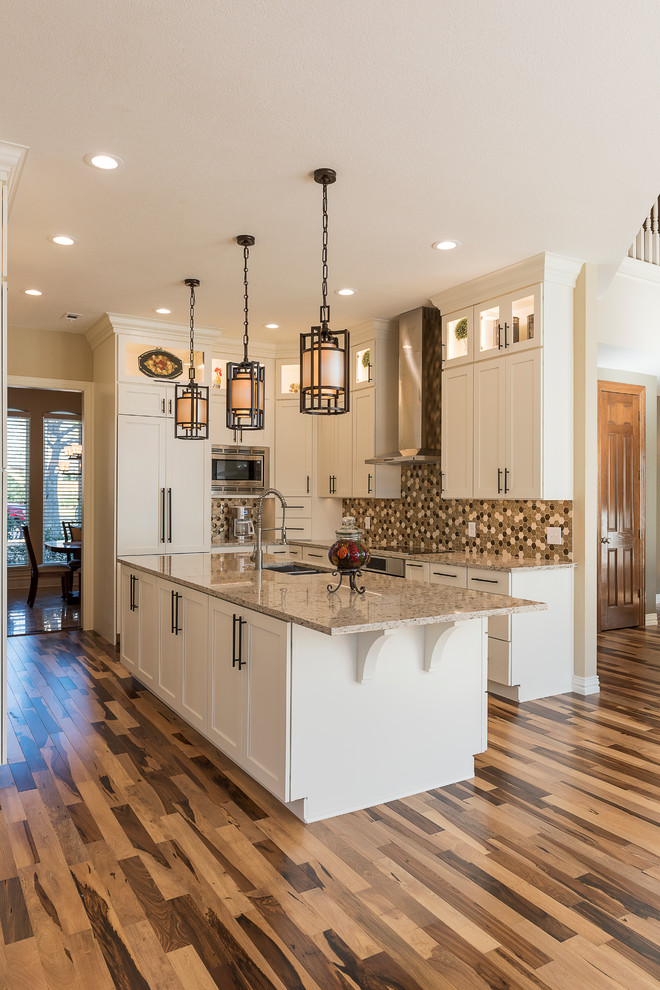 Mid-sized transitional galley light wood floor kitchen pantry photo in Dallas with an undermount sink, shaker cabinets, white cabinets, granite countertops, beige backsplash, ceramic backsplash, stainless steel appliances and an island