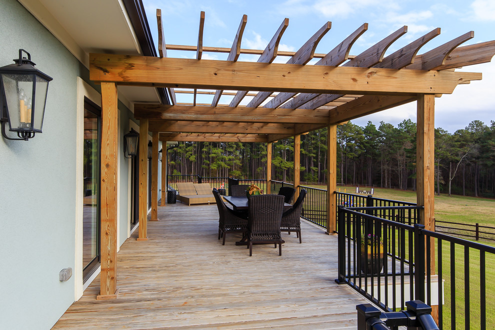 This is an example of a large arts and crafts backyard verandah in Raleigh with decking and a pergola.