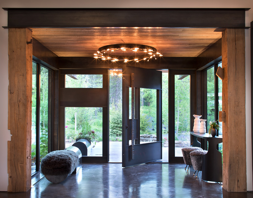 Design ideas for a country foyer in Other with concrete floors, a pivot front door, a glass front door and grey floor.