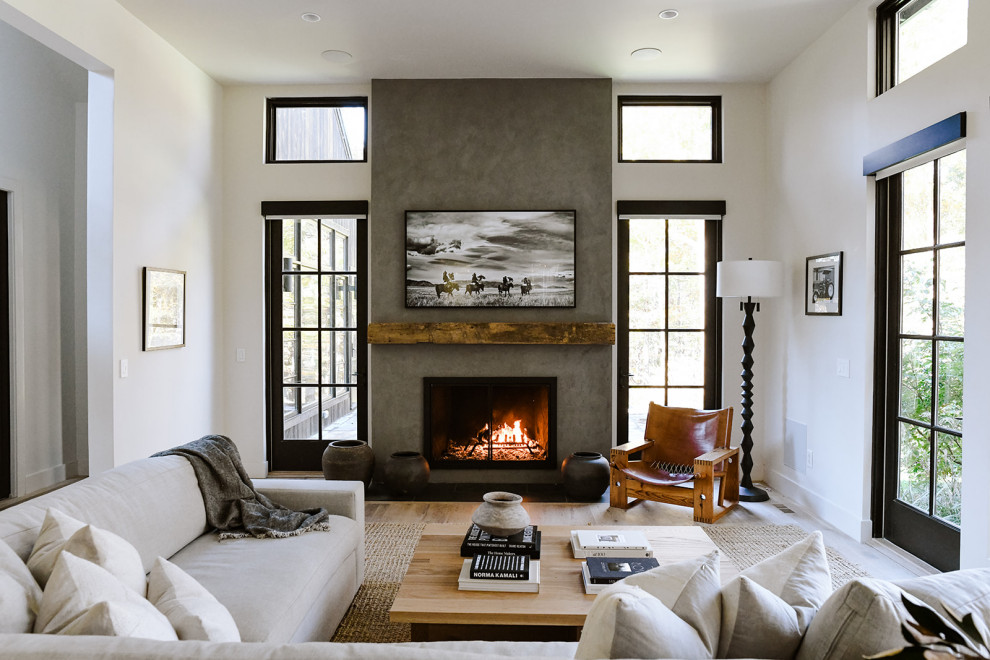 This is an example of a large modern open plan living room in Nashville with white walls, light hardwood flooring, a standard fireplace, a plastered fireplace surround and a wall mounted tv.